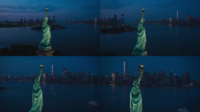空中直升机的电影观自由女神像与曼哈顿天际线的城市景观在晚上。日落时纽约摩天大楼和泽西城建筑的全景