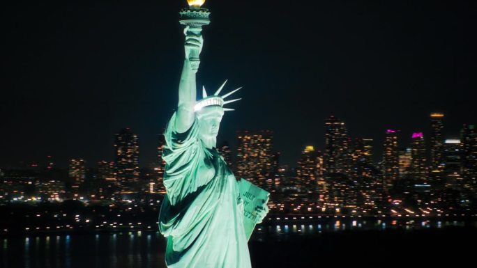 自由女神像的鸟瞰图。曼哈顿和布鲁克林办公大楼的标志性旅游目的地和旅游景点。纽约午夜的场景