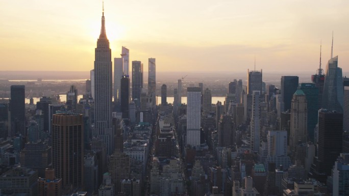 美国纽约市曼哈顿上空鸟瞰全景。空中拍摄的办公大楼，摩天大楼和繁忙的街道在一个阳光明媚的夏夜