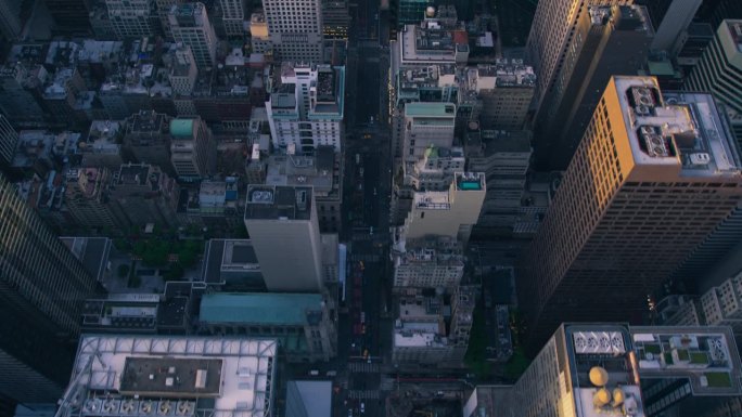 俯瞰纽约曼哈顿街道，商业和住宅建筑屋顶。直升机与汽车、出租车、公共汽车和其他交通工具一起沿着笔直的道