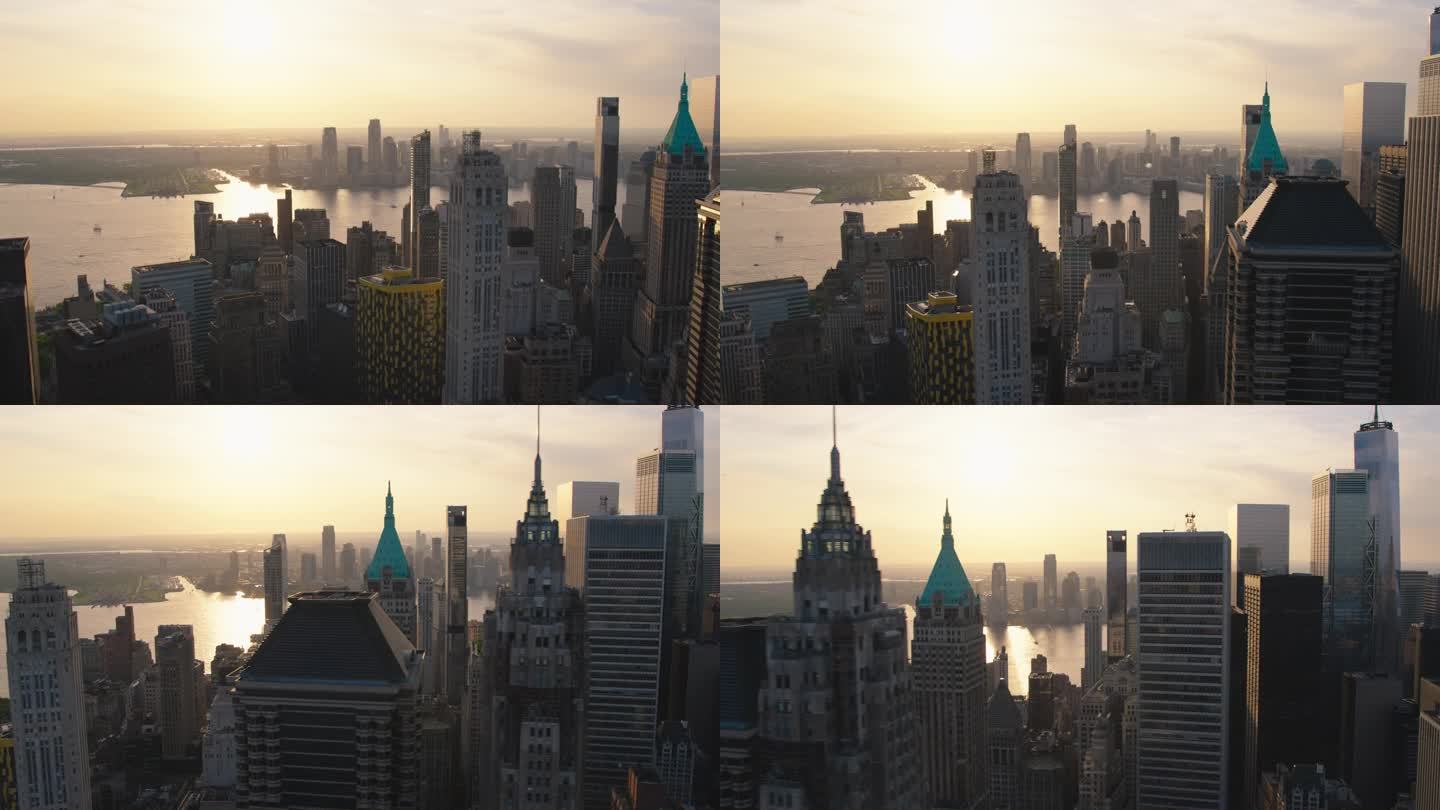 电影航拍日落镜头捕捉纽约市摩天大楼。全景直升机飞越华尔街金融区历史悠久的城市建筑的屋顶和尖塔