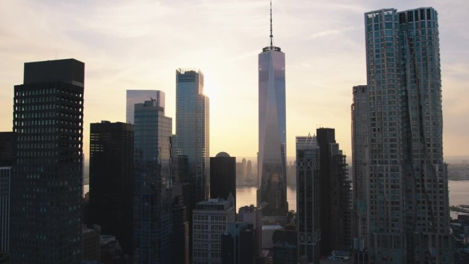 美国纽约曼哈顿下城鸟瞰之旅。从直升机上俯瞰城市风景。大苹果办公大楼和摩天大楼在一个晴朗的夏夜，蓝天白