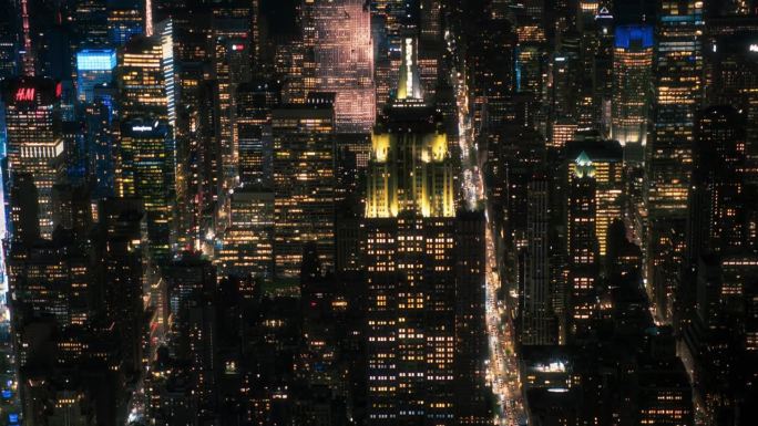 纽约市商业中心。著名的装饰艺术摩天大楼夜间航拍画面。直升机俯瞰帝国大厦，街道和大道上的汽车