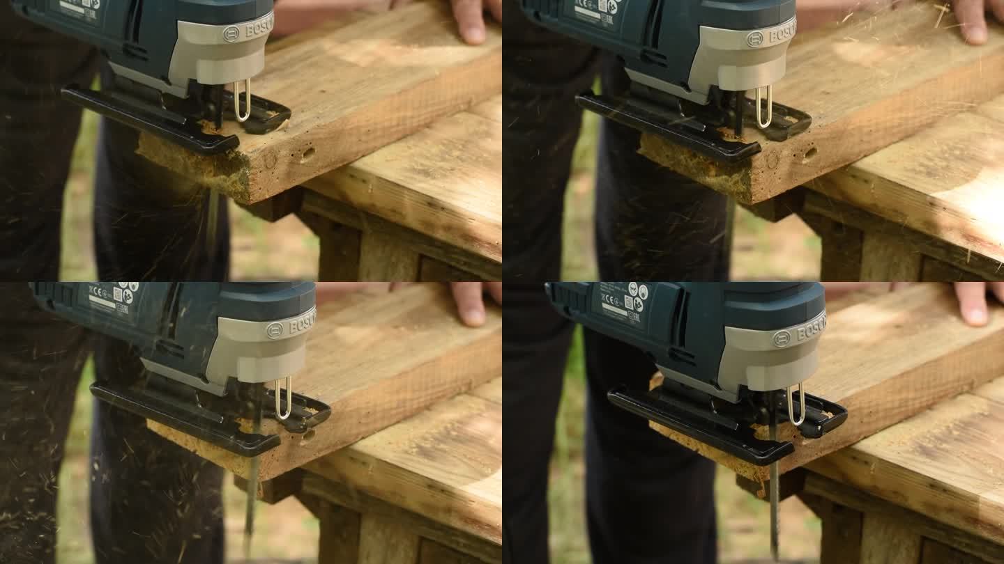 木匠用拼图锯切下一块木板。