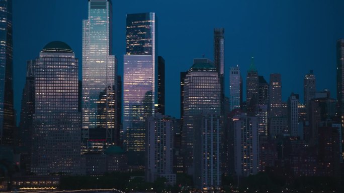 日落时纽约的直升机鸟瞰图。无人机镜头与曼哈顿下城历史摩天大楼反射傍晚的阳光。国际旅游和商业中心的城市