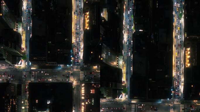 垂直屏幕:俯瞰纽约市街道在夜间与可见网格系统，商业和住宅建筑屋顶鸟瞰图。繁忙的中心有汽车，商用车，行