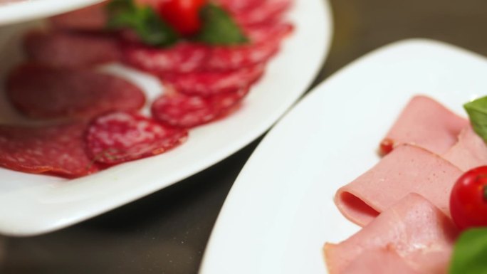 度假时宾馆或饭店的自助餐台。切好的香肠和火腿放在白色盘子里。节日的概念，美味又营养的食物。