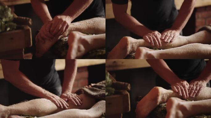 水疗治疗身体和灵魂在澡堂，按摩师擦洗脚和腿的皮肤盐