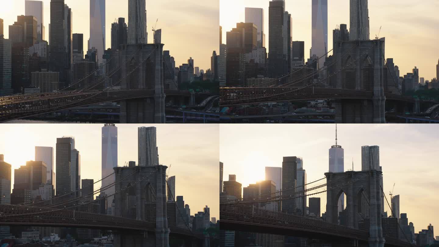 布鲁克林大桥附近的空中电影无人机场景与曼哈顿下城摩天大楼的城市景观。美丽的晚霞闪耀着温暖的晚霞。悬索