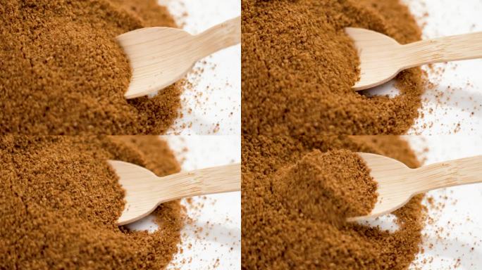 用竹茶匙近距离测量棕椰子糖的分量，制作甜饮料