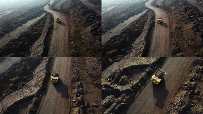 采石场的大型采矿卡车载着铁矿石飞越无人机