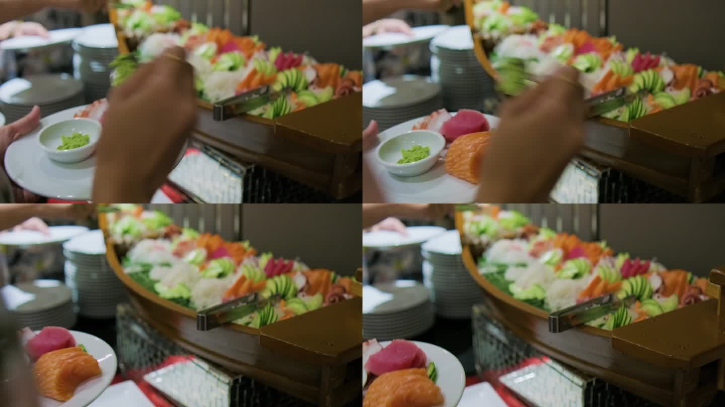 人们在酒店餐厅里抢日式自助餐生鱼片