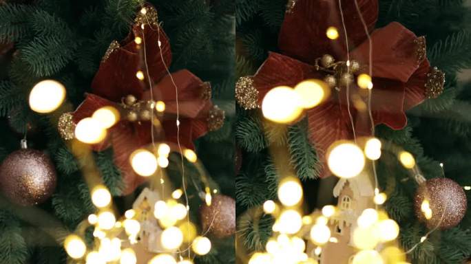 焦点通过灯泡转移到圣诞树上带玩具的花环上。圣诞树上的玩具木屋模型。垂直视频。这棵圣诞树太棒了