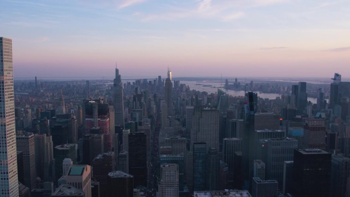 纽约市空中夜景与令人惊叹的曼哈顿地标，摩天大楼和住宅建筑。一个受欢迎的旅游目的地的长广角全景直升机视