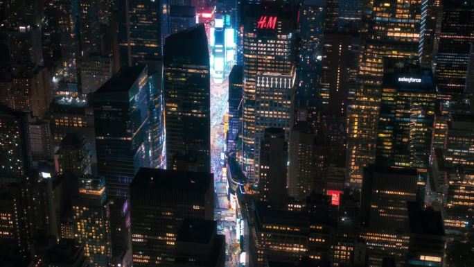 夜晚的纽约混凝土丛林。曼哈顿直升机之旅的航拍画面。现代摩天大楼挡住了拥挤的时代广场游客的视线