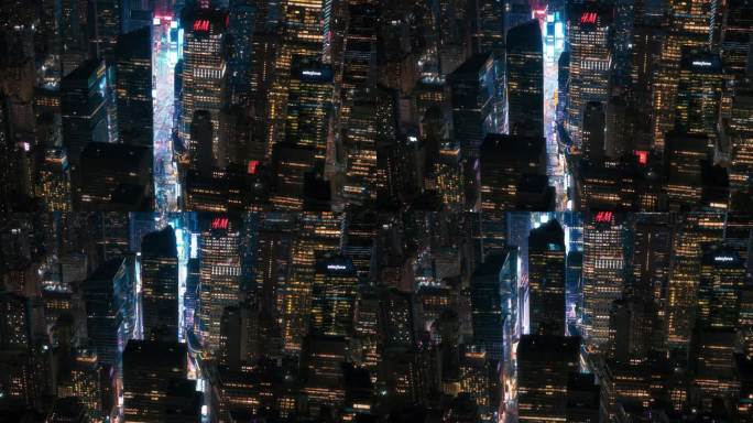 夜晚的纽约混凝土丛林。曼哈顿直升机之旅的航拍画面。现代摩天大楼挡住了拥挤的时代广场游客的视线