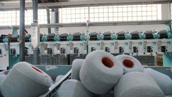 篮子里的一捆捆纱线。纺纱生产。纱线制作工艺。纺织厂设备。线生产。纺织工厂。