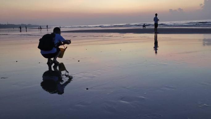 海边日出人物剪影海边人物戏水游玩沙滩夕阳