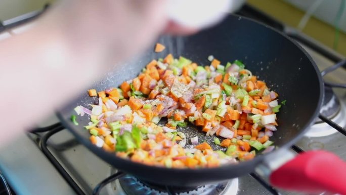 把切碎的混合蔬菜放在锅里，撒上碘盐。高角度拍摄