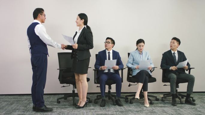 亚洲人力资源经理与女性求职者握手和交谈