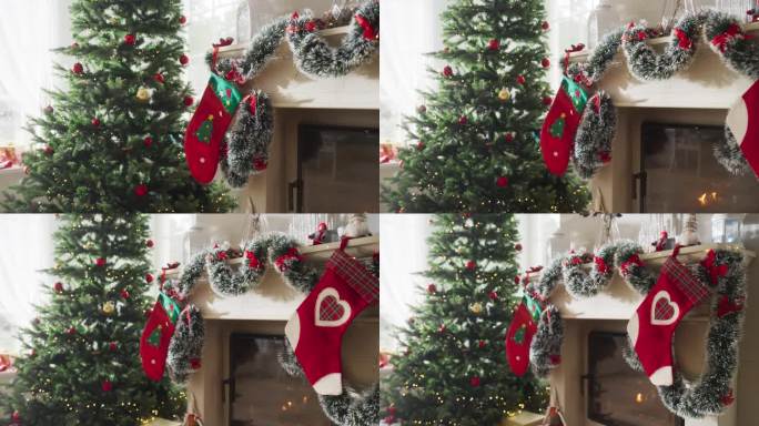 在一个和平的下雪的圣诞节早晨描绘假期的魔力:近距离观察圣诞树旁边装饰着袜子的壁炉。绿色和红色的花环，