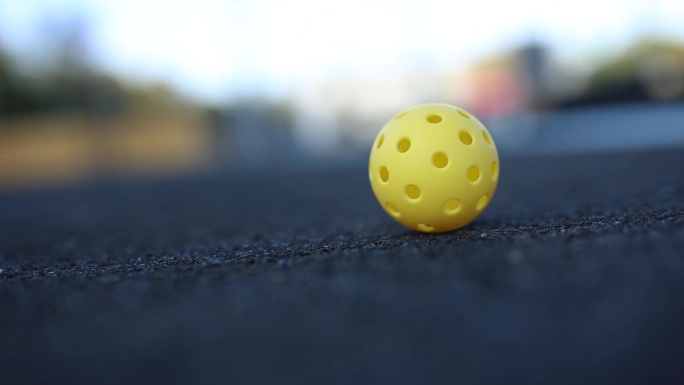 匹克球用的塑料球，在地面上以慢动作旋转