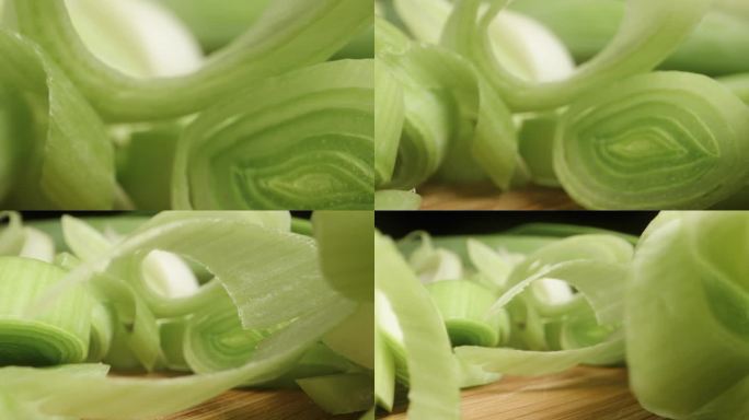 黑色背景上切成片的绿韭菜。多莉滑块极端特写。