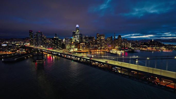 夜幕降临时旧金山的鸟瞰图，沿着海湾大桥上升