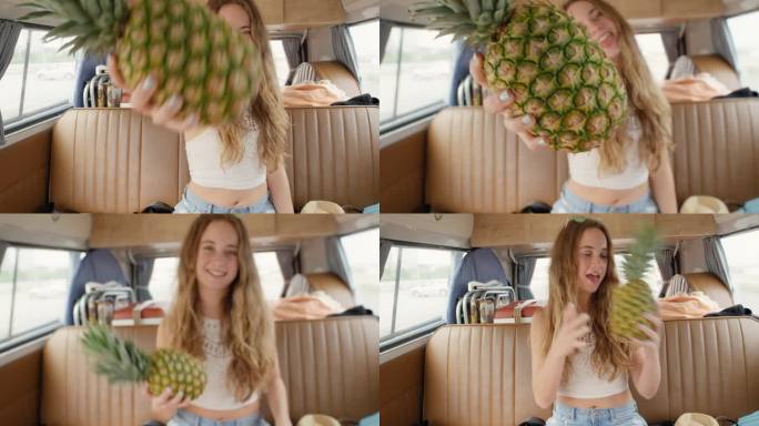十几岁的女孩拿着菠萝，在节日期间在露营车里微笑着拍照