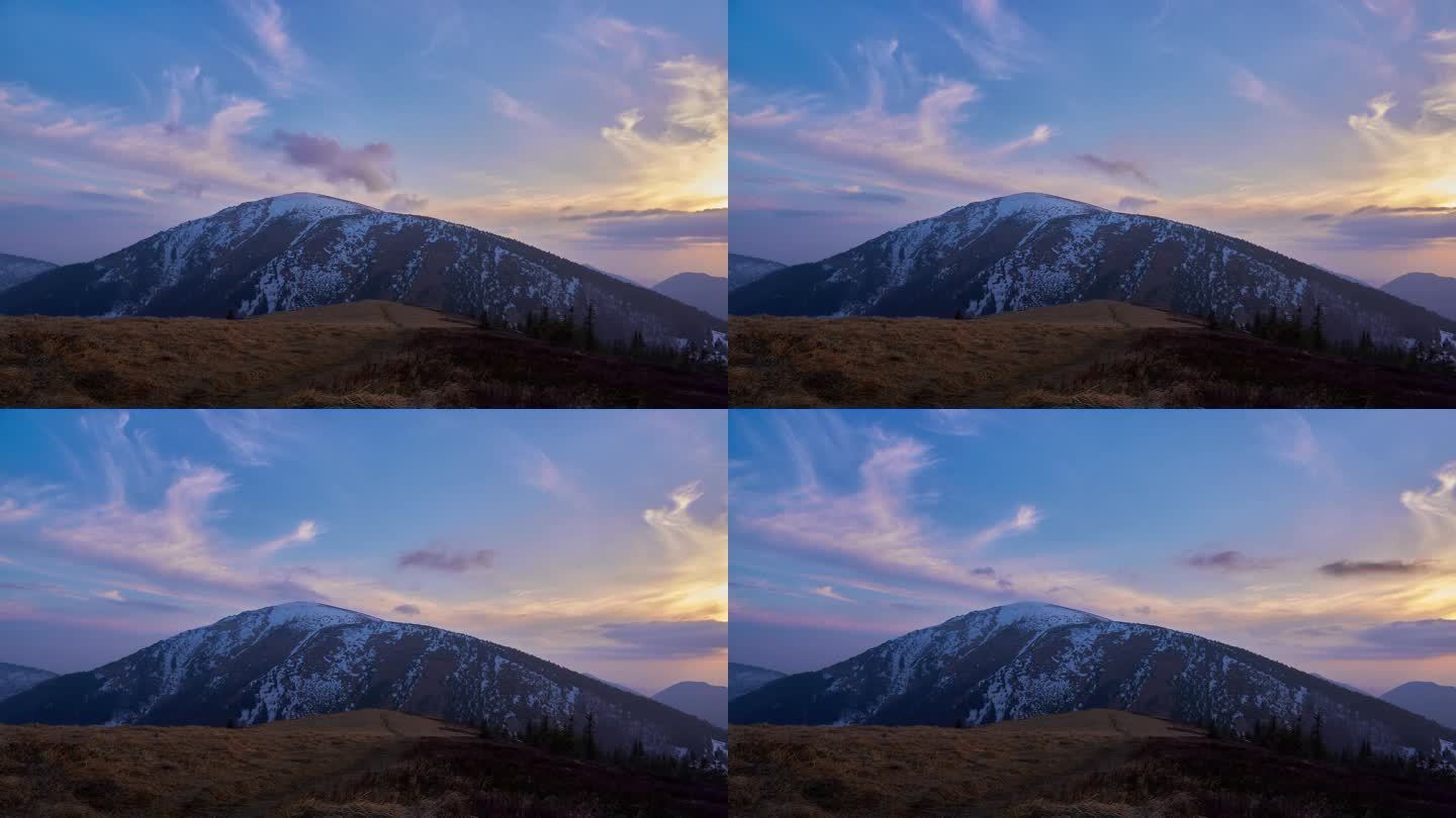 夕阳下的彩云，在春天的山景中，雪融化。