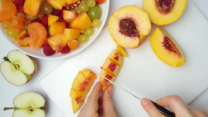 用各种各样的水果和浆果做一份水果沙拉——把油桃切成块
