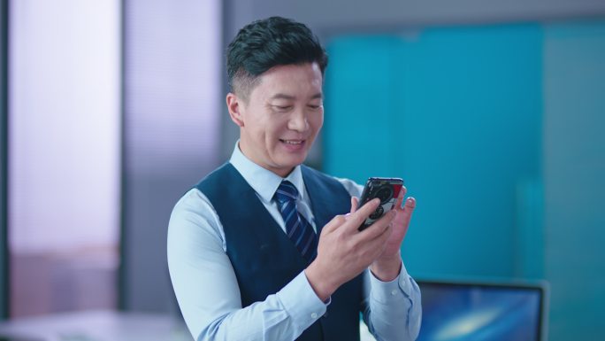 4K商务成功男士微笑看手机