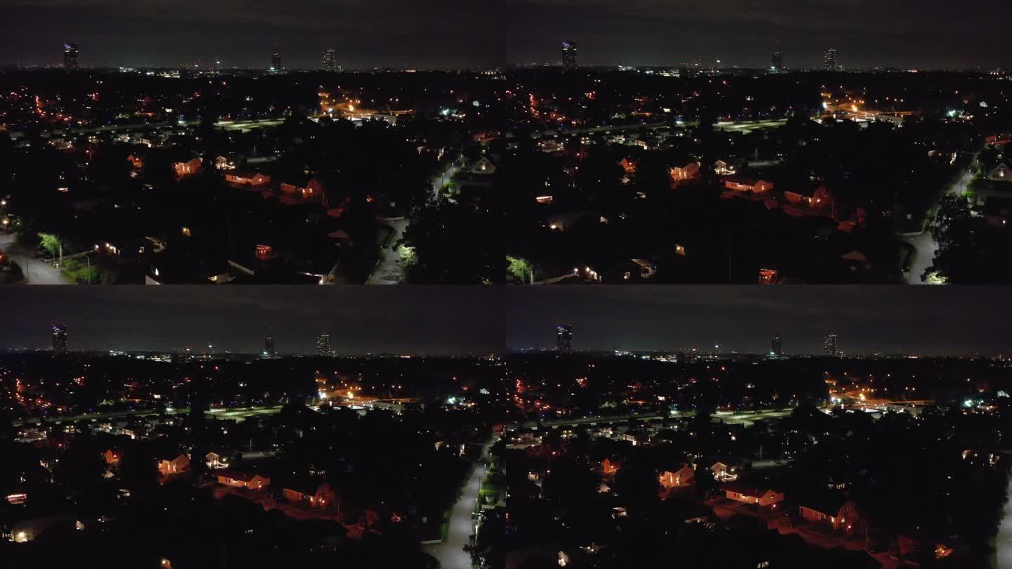 一个住宅区的夜间鸟瞰图，展示了别墅，由一架移动的无人机拍摄。