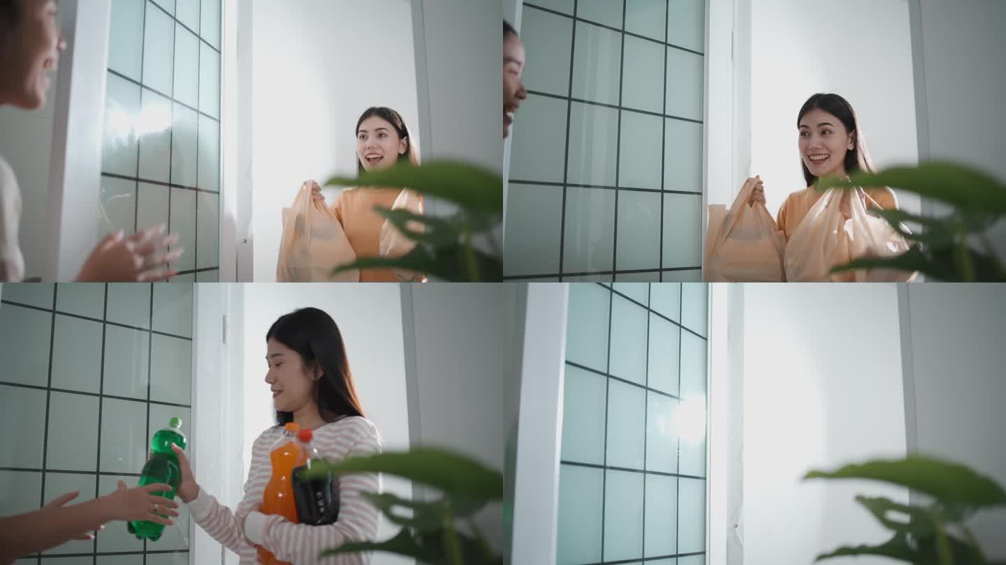 一位年轻的亚洲女子打开门欢迎她的女朋友来她家聚会。