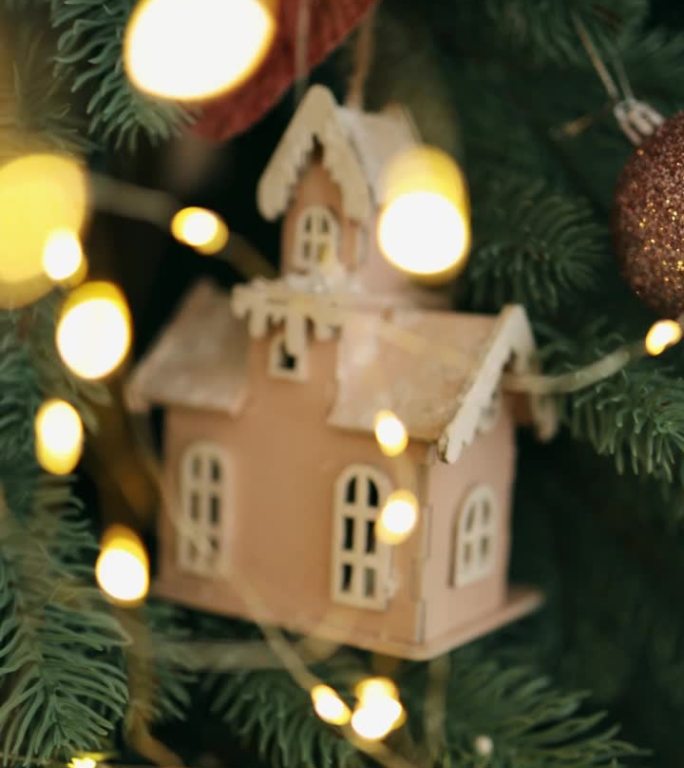 圣诞树上挂着发光的花环的玩具木屋。垂直视频