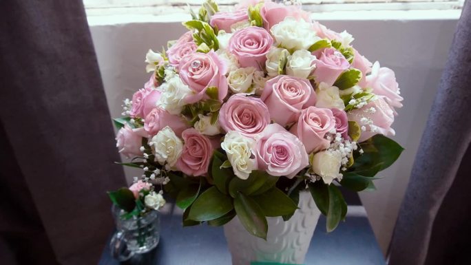 婚礼上的玫瑰，灯光透过窗户进入，照亮了现场，展示了新娘和新郎的精美珠宝