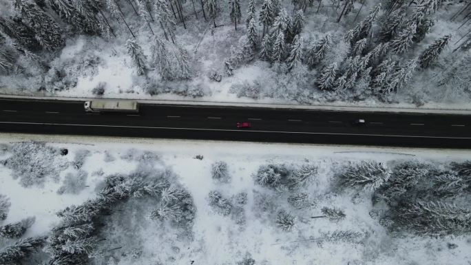 漫长的道路穿过冬天的白雪皑皑的森林