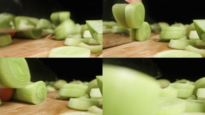 我在黑色背景上切韭菜，相机在微距下捕捉韭菜向前滑动的片段。