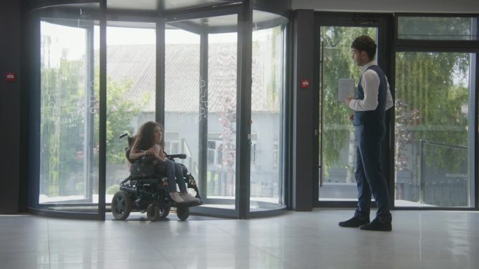 女性残疾患者乘坐旋转门进入诊所