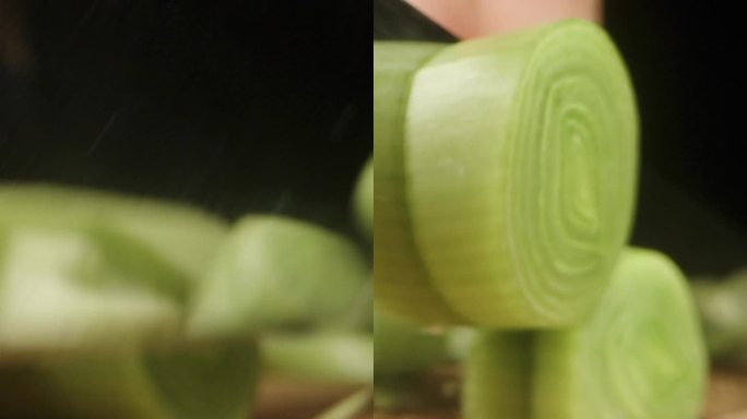 垂直视频。我在黑色背景上切韭菜，相机在微距下捕捉韭菜向前滑动的片段。