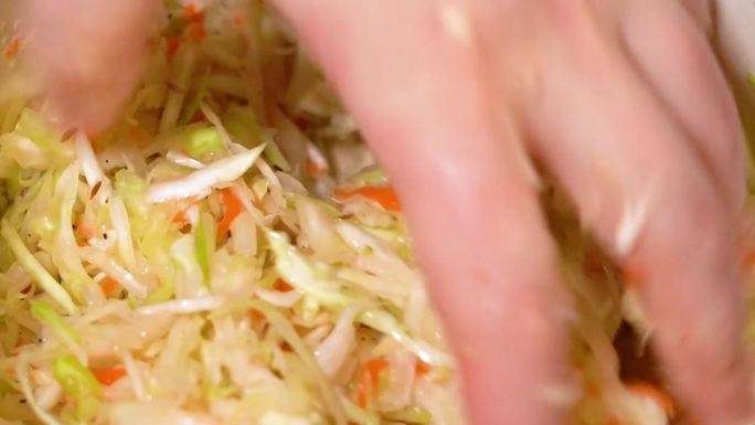 揉碎手卷心菜和胡萝卜蔬菜沙拉。自制的一餐。
