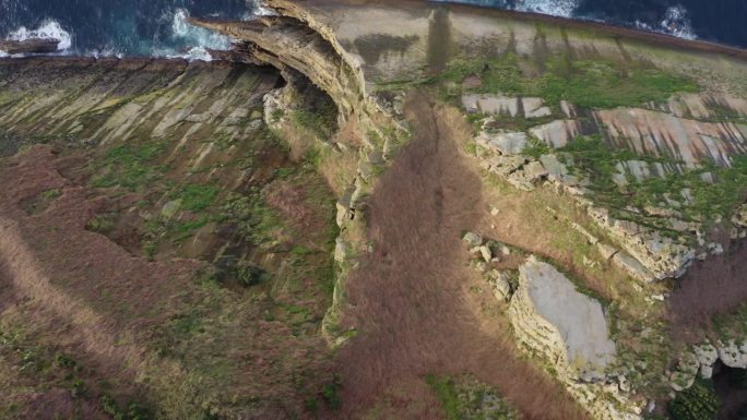从上到下的航拍图显示了悬崖引人注目的尖尖的一面。海岸悬崖
