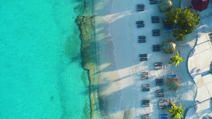 无人机从库拉索岛的格罗特尼普海滩上俯视而下，在躺椅上，长长的影子