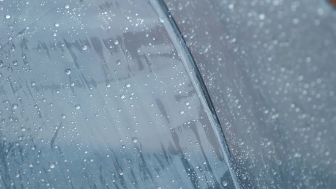 下雨时，雨水顺着透明的雨伞流下。多雨的天气。