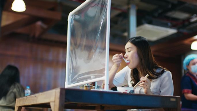 一名亚洲妇女在市场上吃泰式面食