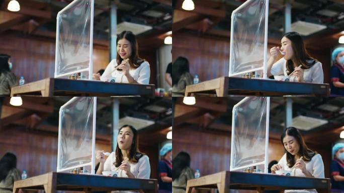 一名亚洲妇女在市场上吃泰式面食