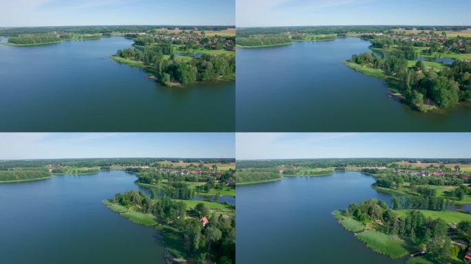 壮丽的鸟瞰平静的湖泊与岛屿在波兰。令人印象深刻的湖屋。天堂湖岸边的乡村房屋。水面上的宁静。绿树、森林
