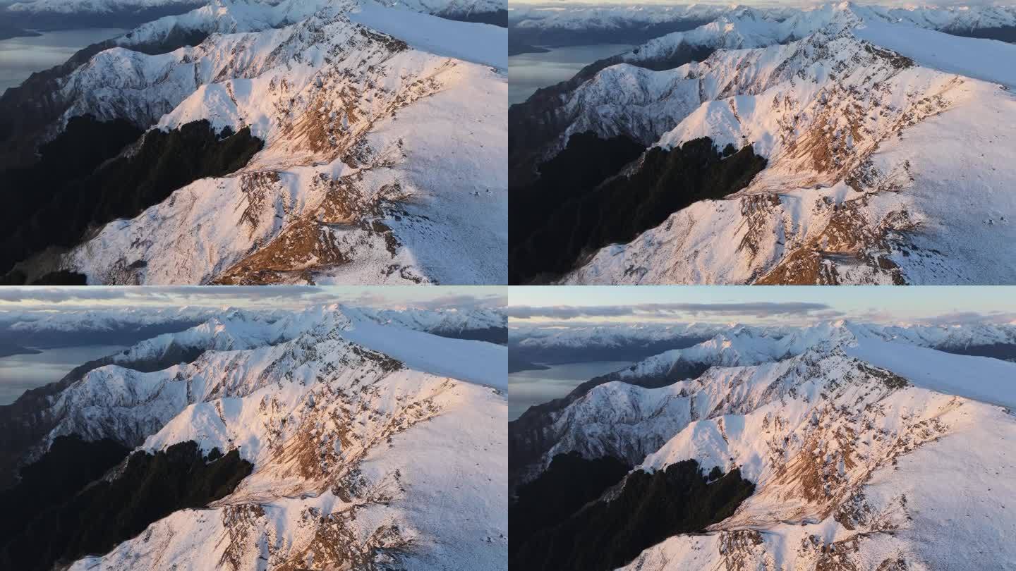 无人机飞越白雪皑皑的山脉，向高山景观开放。新西兰的冬季景观。
