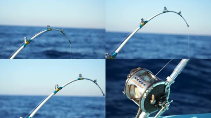 在海上的摩托艇上，电动渔轮旋转并自动停止大渔获的弯曲鱼竿的特写