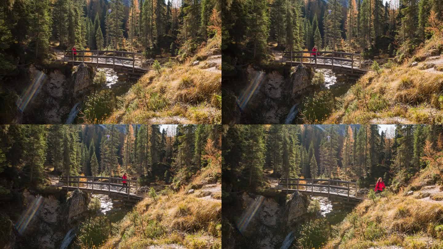 徒步穿越山溪峡谷上的一座桥的妇女